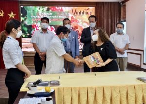 Representatives exchanging documents and shaking hands at the 2021 coffee event